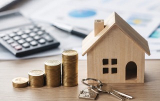 Casa de madera con llaves y monedas que representa que pagar una hipoteca resulta más rentable que alquilar una vivienda en España en 2026.