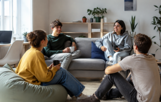 Jóvenes compartiendo piso y conversando en el salón de una vivienda