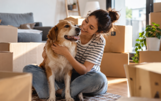 Mujer con su perro en una vivienda de alquiler rodeada de cajas de mudanza